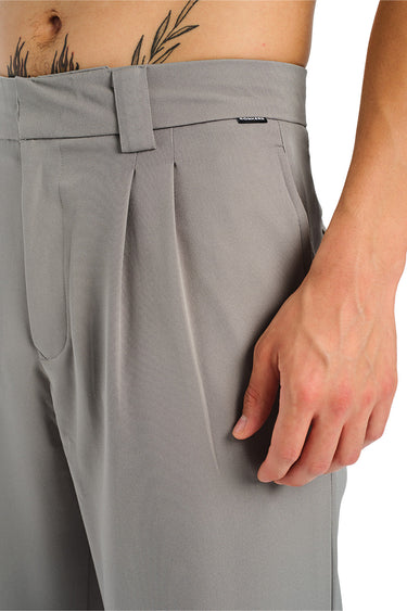Grey loose fit tailored trousers by Bonkers Corner, shown on a model, featuring a relaxed yet structured style for casual or office wear.
