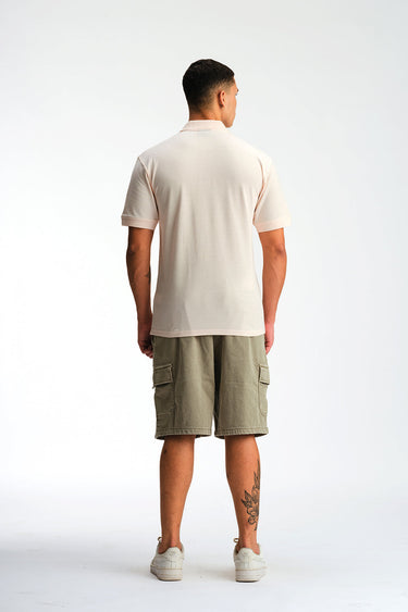 Light pink Bonkers Corner signature jacquard collar premium polo shirt displayed on a hanger.