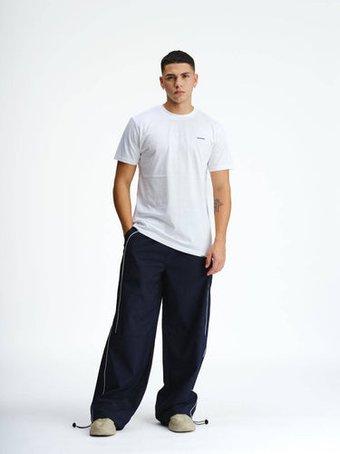 Navy blue sporty deconstructed loose pants by Bonkers Corner, featuring relaxed fit and casual athletic style.