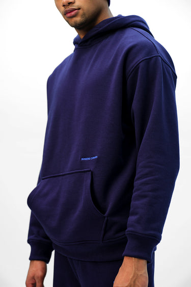 Navy blue Wear A Hug oversized hoodie by Bonkers Corner with a relaxed fit and soft fabric, displayed hanging on a white background.