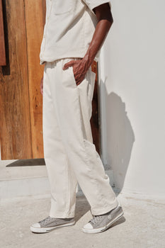 Bonkers Corner off-white corduroy pants, slim fit with textured fabric, shown on a model.