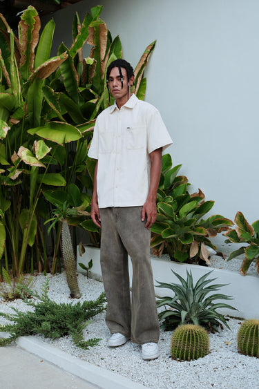 Bonkers Corner Off White Corduroy Shirt displayed on a hanger, showcasing its textured fabric and classic collar design.