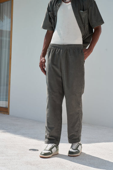 Bonkers Corner olive corduroy pants with a slim fit, featuring textured vertical ridges and classic five-pocket design.