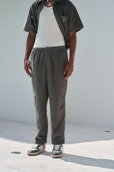Bonkers Corner olive corduroy pants in XS laid flat, showing the textured fabric and classic fit.