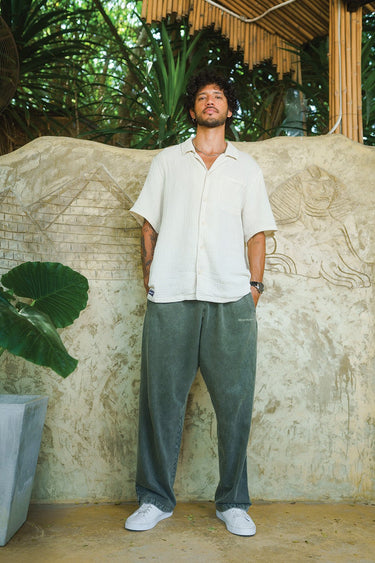 Bonkers Corner olive faded loose-fit pants displayed on a model, showcasing casual, relaxed fit and stylish distressed fabric.