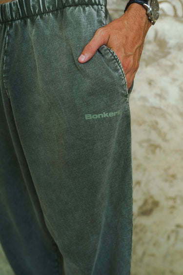 Olive faded loose fit pants by Bonkers Corner, featuring relaxed style and casual comfort, displayed on a model.