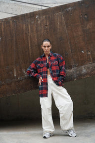 Red and blue checkered oversized shirt by Bonkers Corner, displayed on a hanger showing its casual, relaxed fit and vibrant pattern.