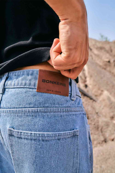 Blue wide-leg straight jeans by Bonkers Corner, shown folded with a classic denim texture and straight-leg style.