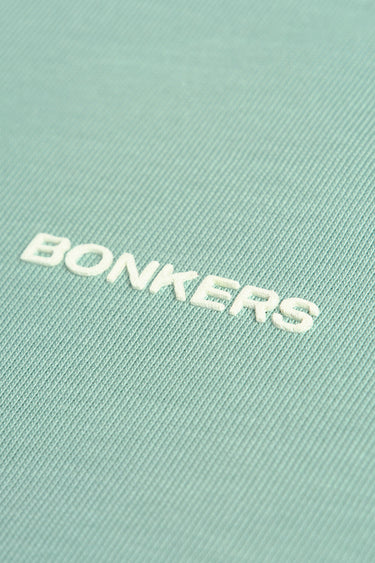 Bonkers Corner sage green Supima cotton regular fit T-shirt displayed flat, showcasing its soft fabric and classic design.