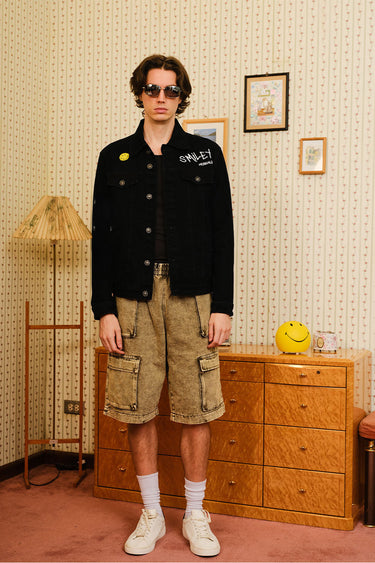 Bonkers Corner Smiley Originals denim jacket with colorful embroidered patches and classic button closure on a mannequin.