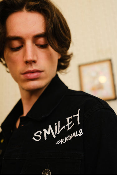 Smiley Originals denim jacket by Bonkers Corner featuring classic blue denim, front buttons, and a relaxed fit.