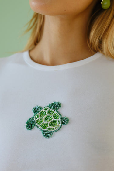 Baby tee from Bonkers Corner with colorful beaded embroidery and a turtleneck design, lightweight and soft for comfortable wear.