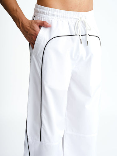 White sporty deconstructed loose pants by Bonkers Corner with a relaxed fit and casual style, shown on a model.