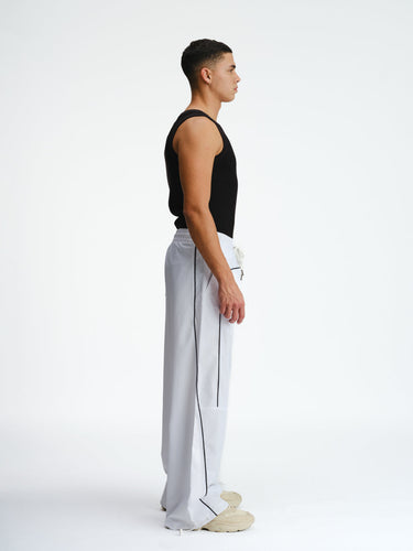 White sporty deconstructed loose pants by Bonkers Corner, featuring a relaxed fit and casual style.