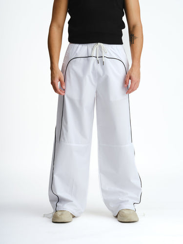 White sporty deconstructed loose pants by Bonkers Corner, featuring relaxed fit and casual style, shown on a model.