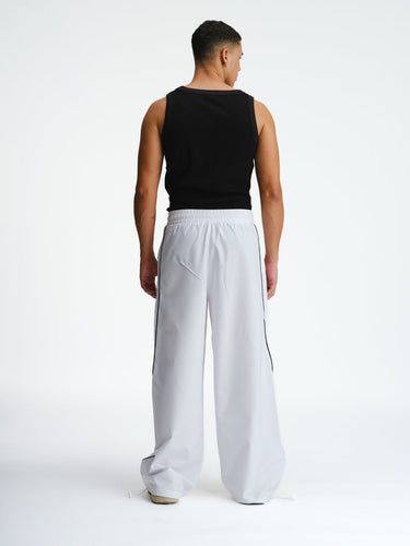 White sporty deconstructed loose pants by Bonkers Corner, featuring a relaxed fit and casual style in the image.