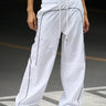 White sporty deconstructed loose pants from Bonkers Corner, showcasing relaxed fit and casual style.