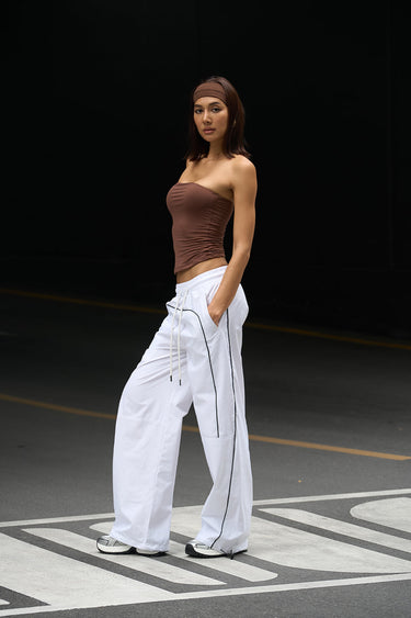 White sporty deconstructed loose pants by Bonkers Corner with a relaxed fit and casual style, shown on a model.