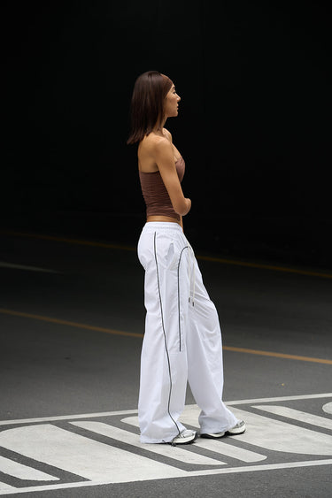 White sporty deconstructed loose pants by Bonkers Corner, relaxed fit with a casual, athletic style.